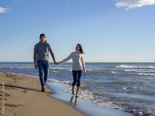 Loving young couple on a beach at autumn sunny day