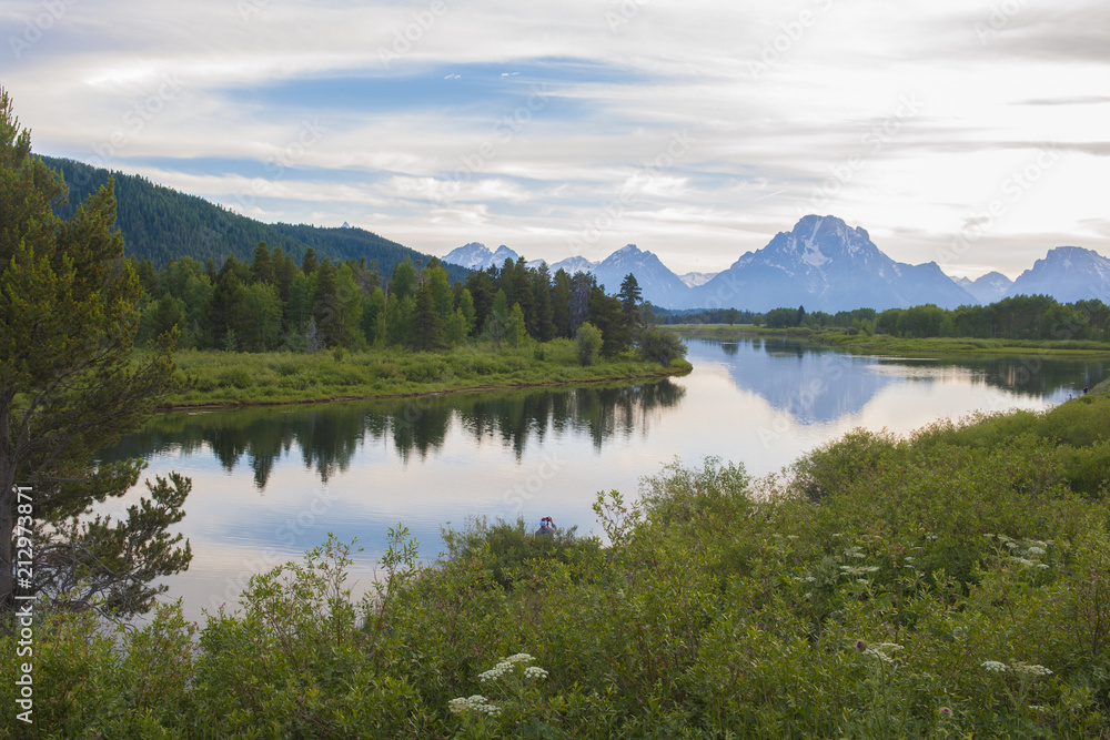 Reflection of the Grand Tetons in the Snake River viewing from Oxbow bend at Grand Teton National Park at sunset