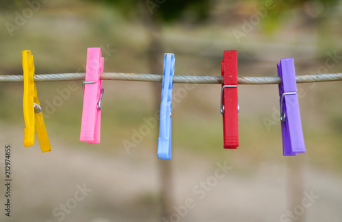 Colorful cloth pegs with a blurred background.