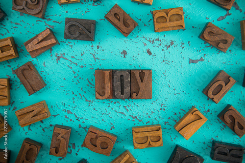 Photography Joy Spelled in Wooden Type Set Block Letters on a Turquoise Background