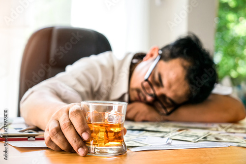 Young businessman Intoxicated sleeping at the table his office while sitting at desk