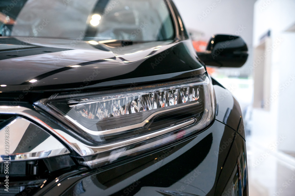 Obraz premium Headlight lamp of new cars parked at a car dealership stock.