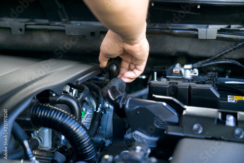 Professional mechanics checking or fixing the engine of a modern car. mechanic performing maintenance and car maintenance.