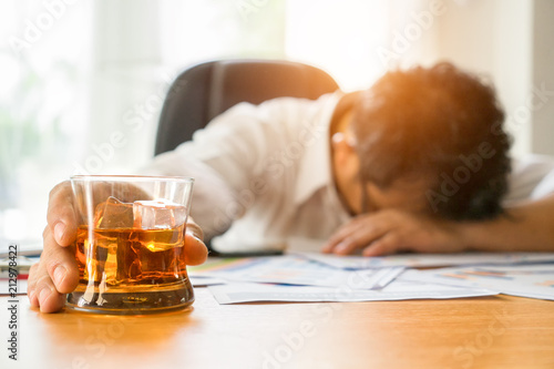 Young businessman Intoxicated sleeping at the table his office while sitting at desk