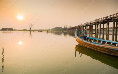 U Bein Bridge on Myanmar . a sunset a boat parked one of the largest wooden bridges in the world