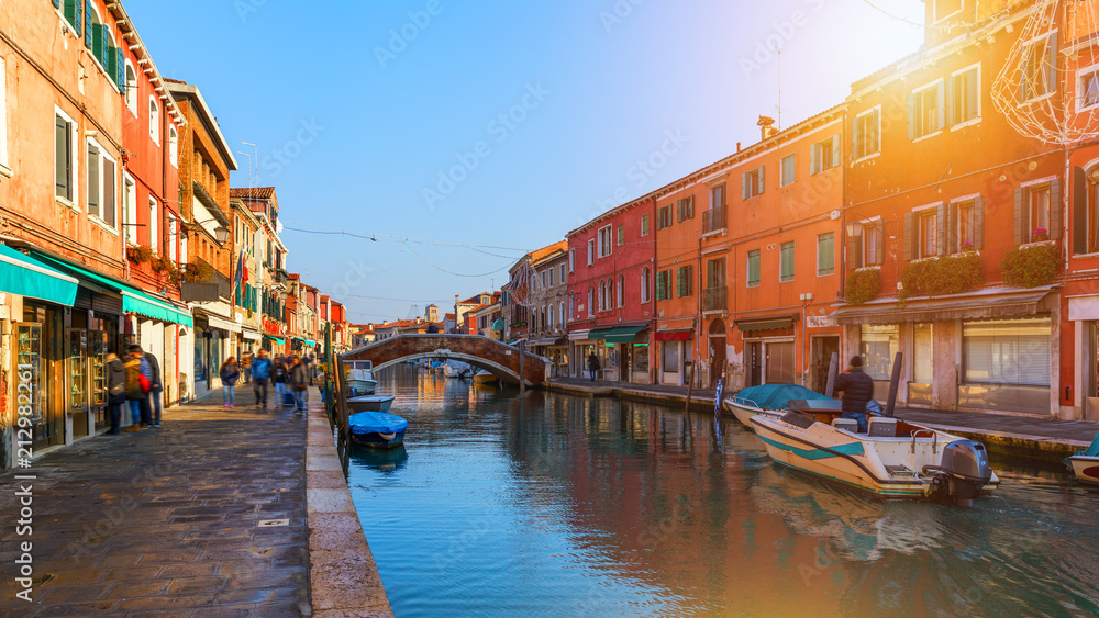 Street canal in Murano island, Venice. Narrow canal among old colorful brick houses in Murano, Venice. Murano postcard, Venice, Italy.