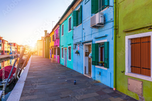 Street with colorful buildings in Burano island, Venice, Italy. Architecture and landmarks of Burano, Venice postcard. Scenic canal and colorful architecture in Burano island near Venice, Italy © daliu