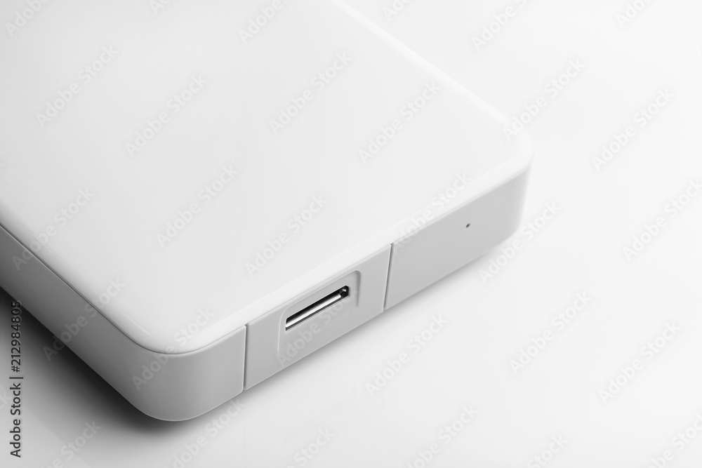 External hard drive of white color on a white background. Information base. Additional memory. Data storage. Repair of computer equipment. Closeup.