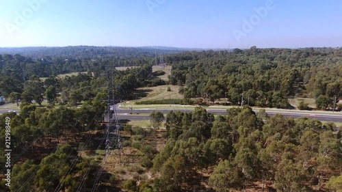 Drone over hightension power lines with bushland and road in background photo