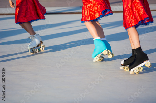Horizontal View of Three Girls Skating with a Red Skirt on Blur Background