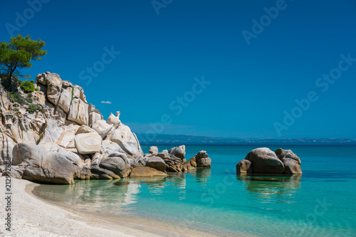 Tropical sandy beach with large rocks and blue sea