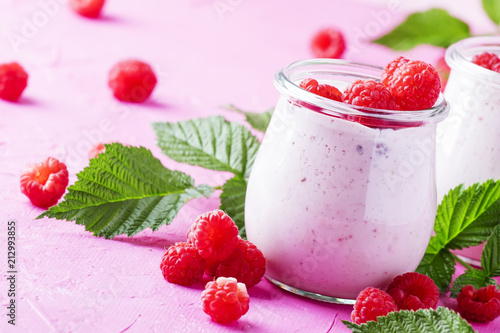 Raspberry smoothie with berry and yogurt on pink background, selective focus