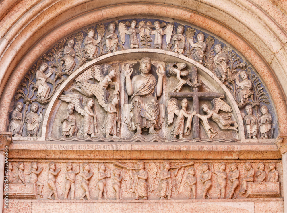 PARMA, ITALY - APRIL 17, 2018: The romanesque relief of Jesus Christ among the angels and twelv apostles on the portal of Baptistery.