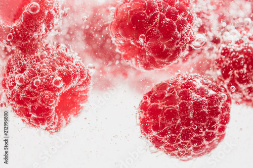 Fresh raspberries in water wiht air bubbles.