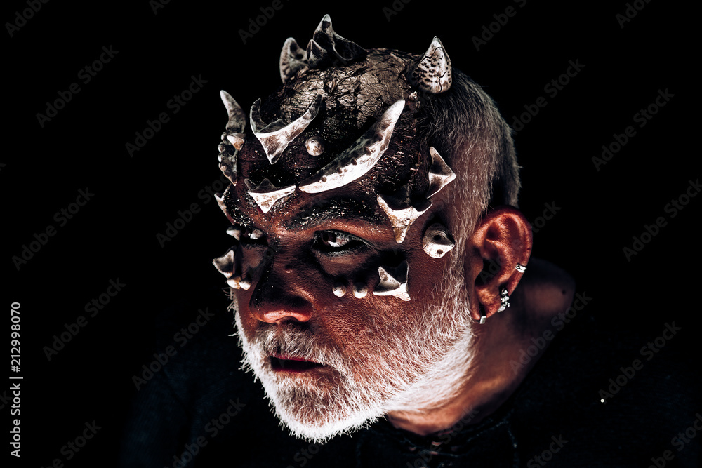 Premium Photo  Monster with thorns and red dragon skin stern demon face  with evil look isolated on black background man with fancy makeup halloween  concept