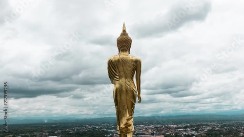 stormy and cloud is moving golden buddha standing in a mountain temple
