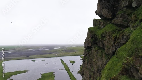 smooth drone shot with brids and close cliff in iceland photo