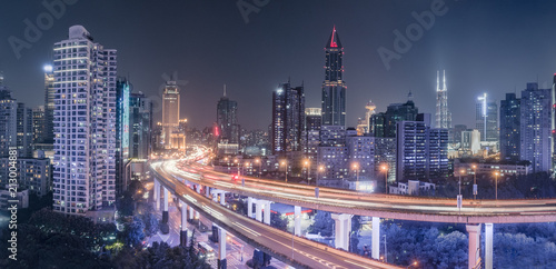 aerial view of buildings and traffic multi-level junction at night in Shanghai city