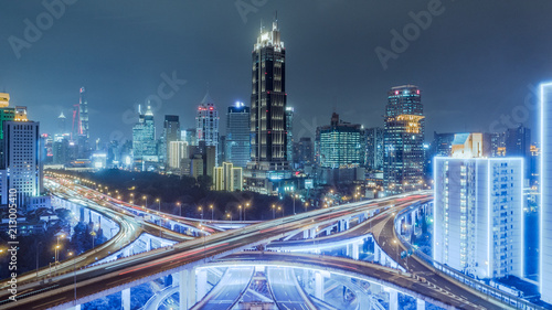 aerial view of buildings and highway interchange at night in Shanghai city