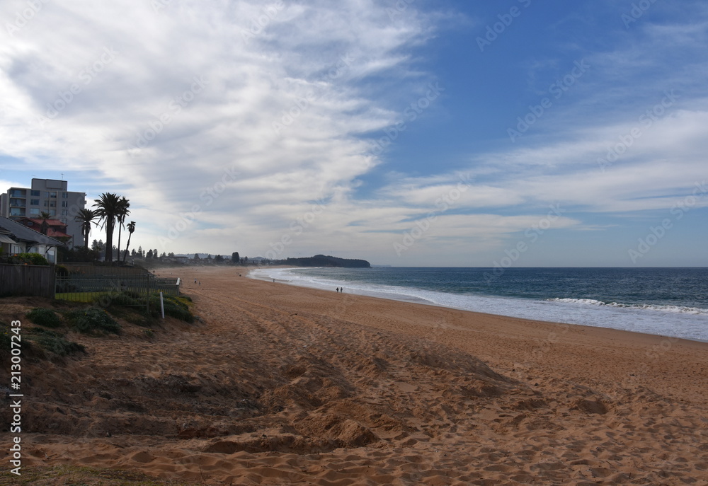 Panoramic view of Narrabeen beach on a cloudy day. A great place to relax as the beach is mainly frequented by locals. Panoramic view of Narrabeen beach on a cloudy day. A great place to relax as the beach is mainly frequented by locals.