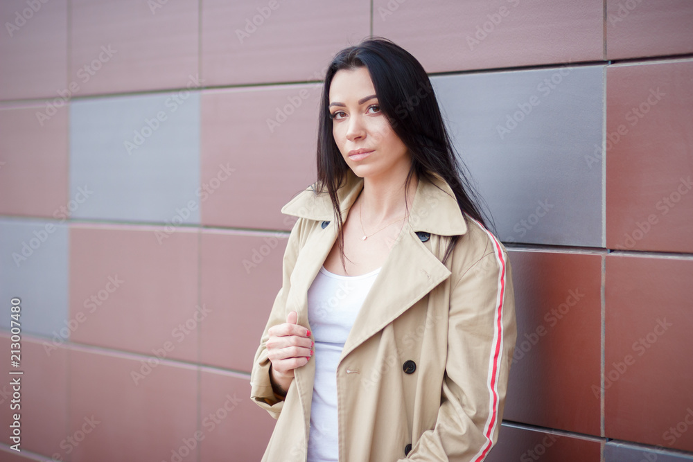 Beautiful woman in the beige coat and jeans on the street Beautiful woman in the beige coat and jeans on the street