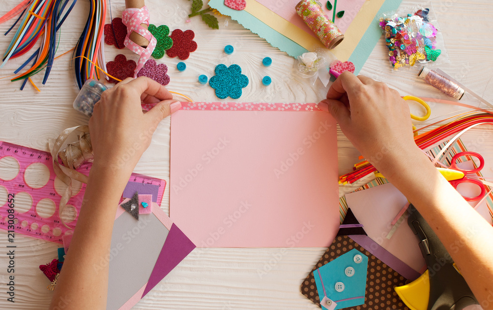 Naklejka premium Woman's hand cut paper, scrapbooking for wedding or other festive decorations . Tools for scrapbooking.