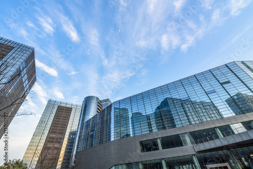 Bottom view of modern skyscrapers in business district against blue sky.