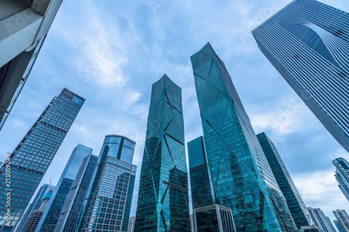 Bottom view of modern skyscrapers in business district against blue sky.