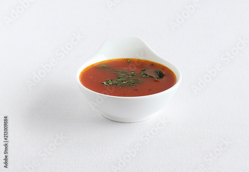 Tomato rasam, a traditional, popular and healthy south Indian vegetarian semi-liquid food is consumed as an appetizer or eaten with mixing the rasam with rice, in a bowl. photo