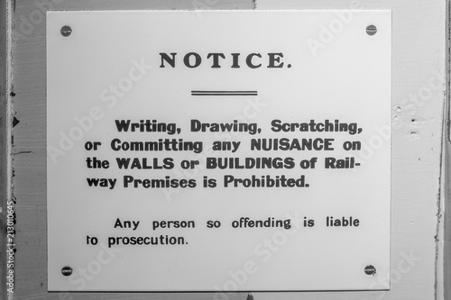 Tablou pe pânză a black and white retro sign on the wall of a railway station