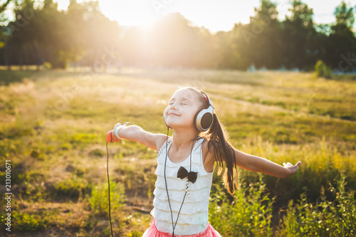 fine girl listening music with headphones and dancing, cute child enjoying music and resting