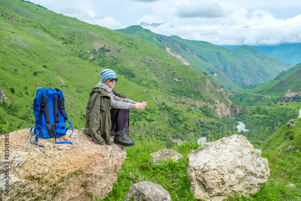 A girl in the mountains is resting. Mountain landscape. A girl in the mountains is resting. Mountain landscape.