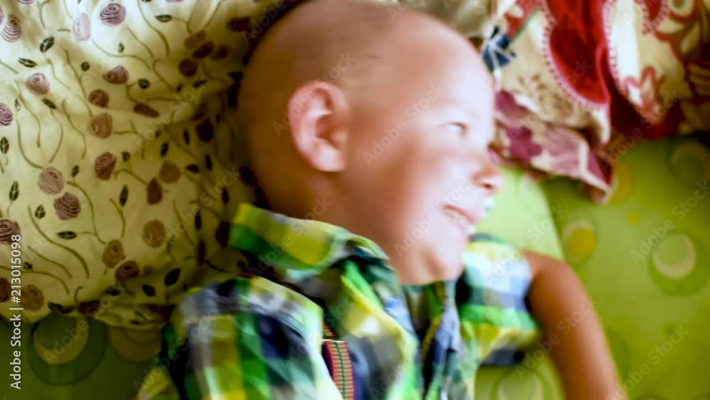 The little boy covered his face with his hands on the bed. The little boy covered his face with his hands on the bed.