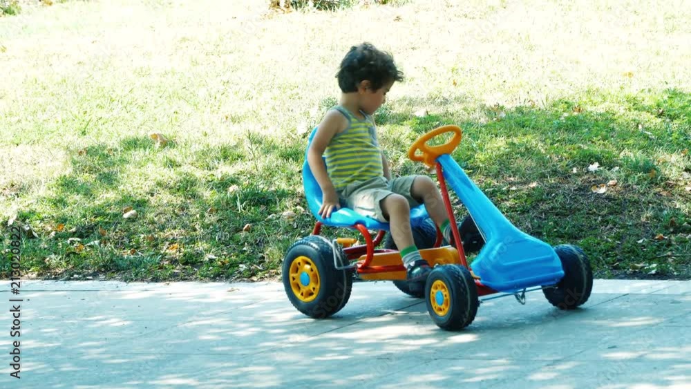 Happy child driving the small toy car in attraction park. 4K Happy child driving the small toy car in attraction park. 4K
