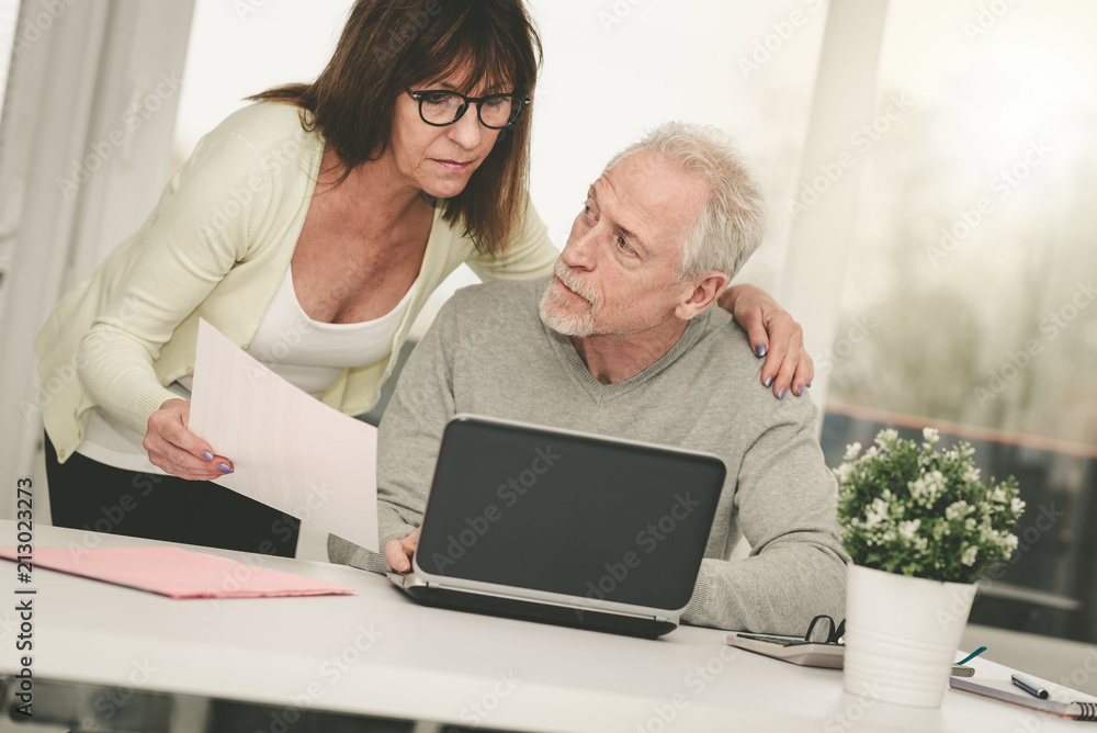 Senior couple checking financial document Senior couple checking financial document