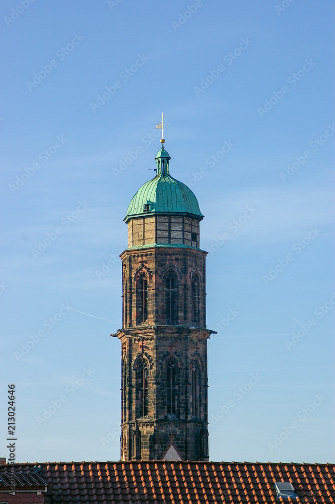 Kirchturm mit kupferdach vor blauem himmel
