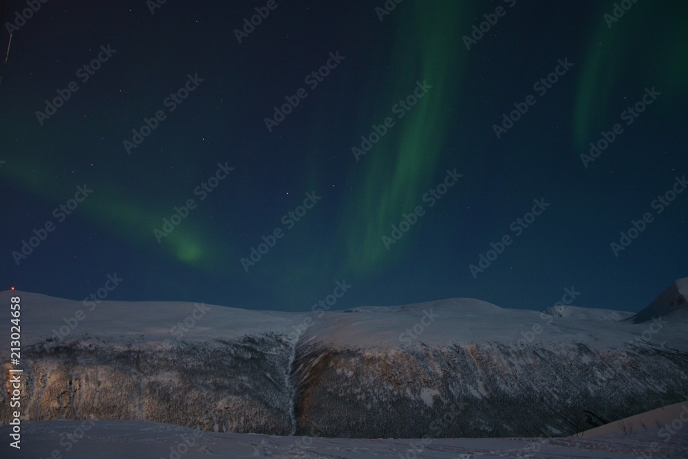 The northern lights (Aurora Borealis) and the city scape from Fjellheisen Peak over the city