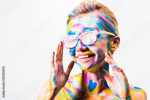 smiling attractive girl with colorful bright body art and sunglasses isolated on white