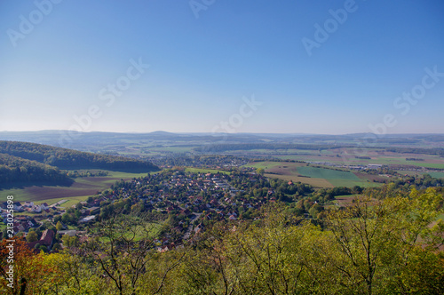 Blick in einer ferne Landschaft mit einem kleinen Dorf unter wolkenlosem Himmel