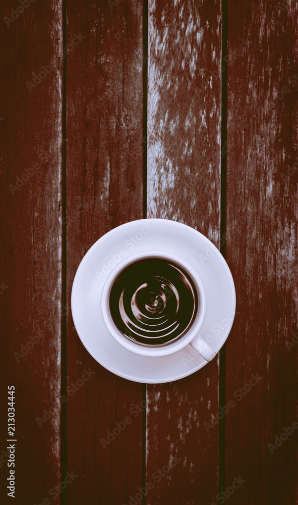 Black coffee in white cup on wood background, vertical style, vintage tone style Black coffee in white cup on wood background, vertical style, vintage tone style