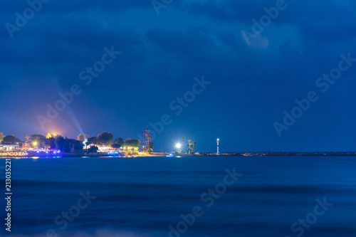 beautiful night view of the sea and the port in the illumination with the lighthouse of the city. Side, Turkey