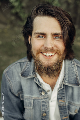 Photos A large-sized portrait of a bearded dark-haired guy in a blue jeans similar to
