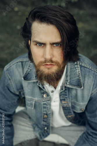 Tableau sur toile A large-sized portrait of a bearded dark-haired guy in a blue jeans similar to