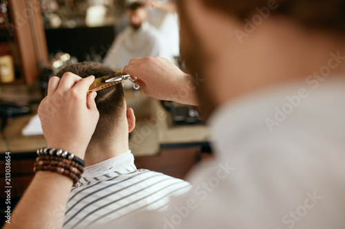 Men Haircut. Barber Cutting Man's Hair In Barber Shop 