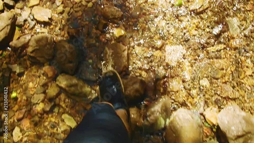 SLOWMO, Person walking in sneakers through a shallow rocky creek. Christoffelpark, Curacao. photo