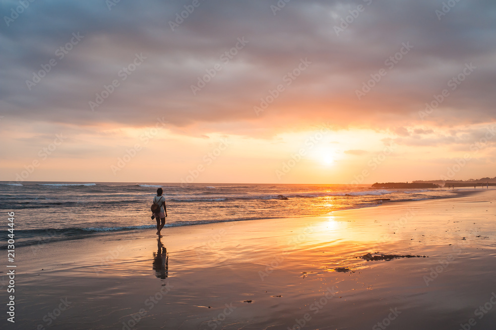 Sunset on the beach in Bali with a young woman