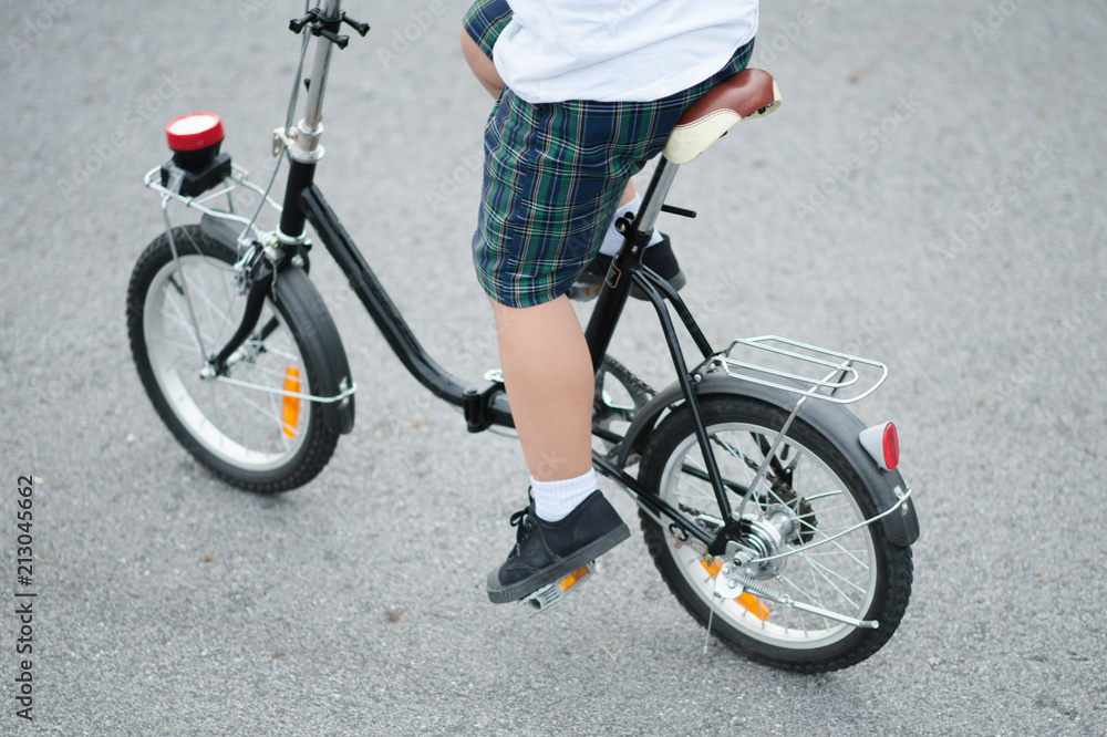 Fototapeta premium child on a bicycle at asphalt road.