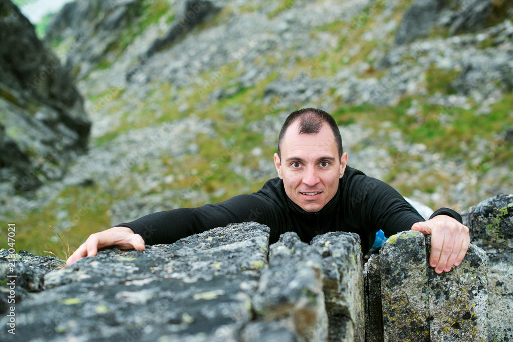 Man climbing the mountain rock. Man travels in mountains. Outdoors activities, camping, hiking, climbing. Healthy lifestyle concept. Сonfident man goes to his goal.Young man love mountains adventure. Man climbing the mountain rock. Man travels in mountains. Outdoors activities, camping, hiking, climbing. Healthy lifestyle concept. Сonfident man goes to his goal.Young man love mountains adventure.