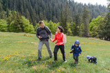 Couple with Children Walking on Meadow