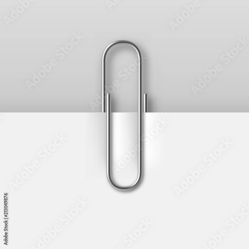 Realistic metal paper clip on white paper sheet. Office stationery vector illustration isolated on gray background. Simple device for binding documents together. Mockup paper clip attachment
